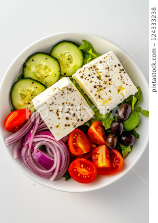 Greek salad with feta cheese, cucumber, tomato, onion and olives in a white bowl Greek salad with feta cheese, cucumber, tomato, onion and olives in a white bowl 124333238