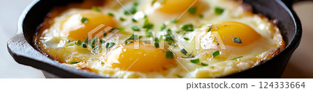 Four eggs sunny side up are cooking in a cast iron pan, seasoned with chives and pepper Four eggs sunny side up are cooking in a cast iron pan, seasoned with chives and pepper 124333664