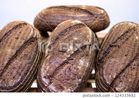 Loaves of dark rye bread on shelf in bakery. Sale of baked goods in the store. 124333682
