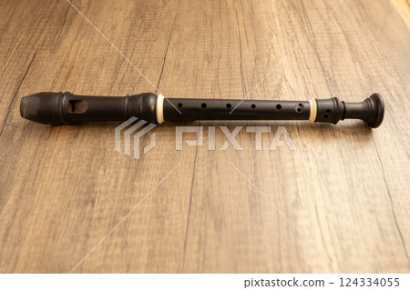 Ebony soprano recorder on a wooden table 124334055