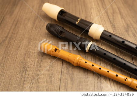 Three recorders on a wooden table: alto, soprano, and sopranino Three recorders on a wooden table: alto, soprano, and sopranino 124334059