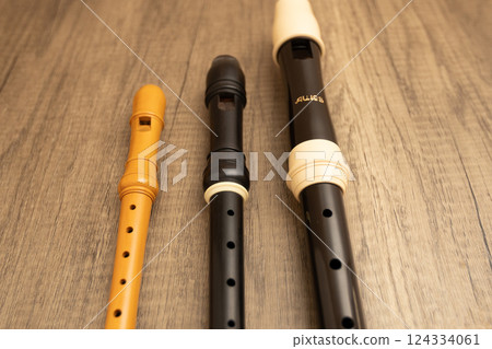 Three recorders on a wooden table: alto, soprano, and sopranino Three recorders on a wooden table: alto, soprano, and sopranino 124334061