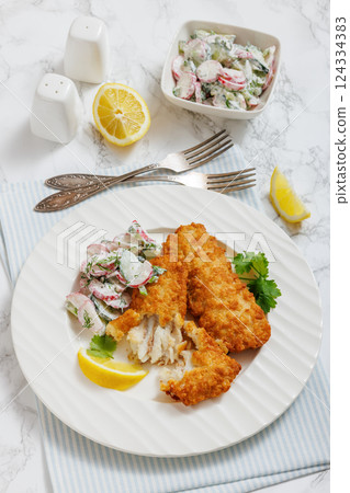 fried battered fish fillets with radish dill salad 124334383