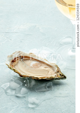 Oyster with a glass of wine, on ice, on a slate background 124334569
