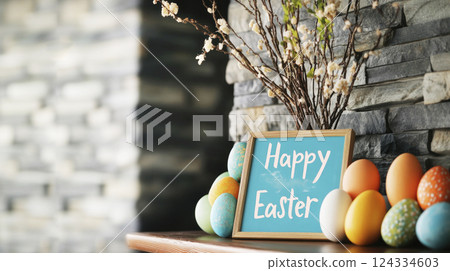Happy Easter wooden sign, vivid Easter eggs, spring twigs on wooden fireplace shelf, gray rock wall. Happy Easter wooden sign, vivid Easter eggs, spring twigs on wooden fireplace shelf, gray rock wall. 124334603
