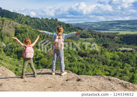 Girls embracing freedom and adventure on a mountaintop hike Girls embracing freedom and adventure on a mountaintop hike 124334652