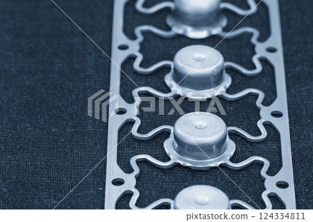 Sample of stamping part of metal drawing process on the progressive die in the light blue scene. Sample of stamping part of metal drawing process on the progressive die in the light blue scene. 124334811
