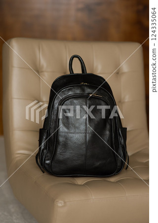 Black leather backpack on a chair 124335064