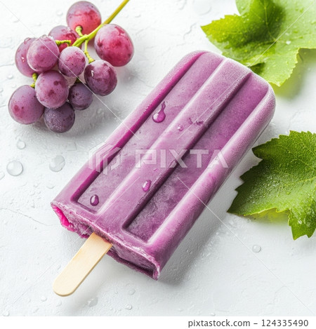 National Grape Popsicle Day Grape popsicle and fresh grapes with green leaves on a cool white surface 124335490