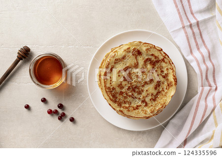 Crepes thin pancakes with honey on a white plate Crepes thin pancakes with honey on a white plate 124335596