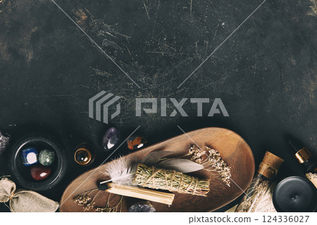 Mystical Flat Lay of Sage, Crystals, and Dried Herbs on Dark Surface 124336027