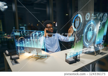 Innovative Professional Analyzing Data on Transparent Digital Interface in Modern Office Setting Innovative Professional Analyzing Data on Transparent Digital Interface in Modern Office Setting 124336173