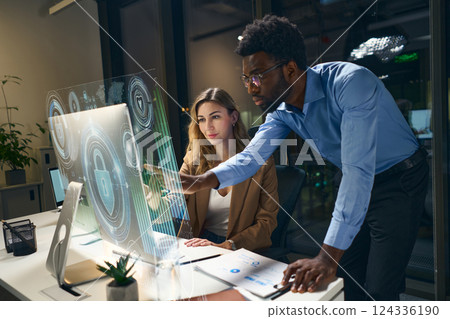 Professionals Collaborating Over Digital Interface for Cybersecurity Analysis in Modern Office 124336190