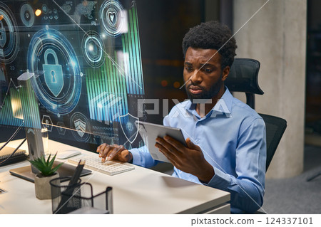 Cybersecurity Analyst Examining Data On Multiple Devices In A Tech Office Environment Cybersecurity Analyst Examining Data On Multiple Devices In A Tech Office Environment 124337101