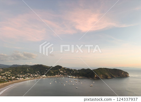 Sunset view of tranquil bay with boats and shoreline in coastal town Sunset view of tranquil bay with boats and shoreline in coastal town 124337937