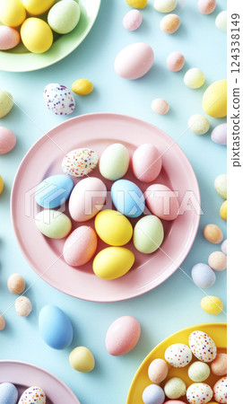 Colorful pastel Easter eggs on round plates on pastel blue background. Modern Easter flatlay design. 124338149