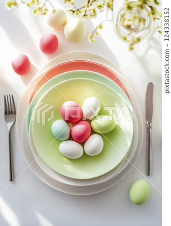 Easter trendy pastel table setting Easter eggs on round plates on white top view Soft light, shadows Easter trendy pastel table setting Easter eggs on round plates on white top view Soft light, shadows 124338152
