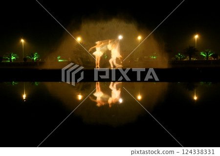 Reflection of the night light show on the water. 124338331