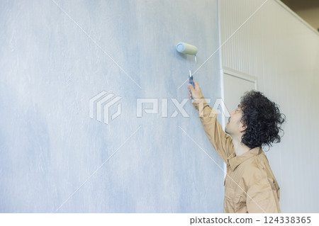 一名身穿工作服的男子正在作畫 一名身穿工作服的男子正在作畫 124338365