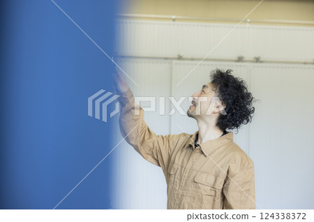 一名身穿工作服的男子正在作畫 124338372