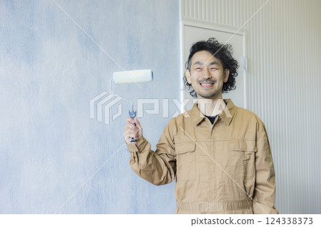 一名身穿工作服的男子正在作畫 一名身穿工作服的男子正在作畫 124338373