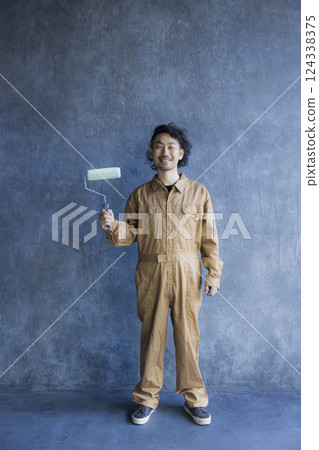 一名身穿工作服的男子正在作畫 124338375