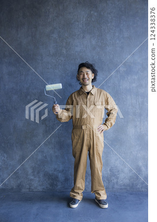 A man in overalls painting 124338376