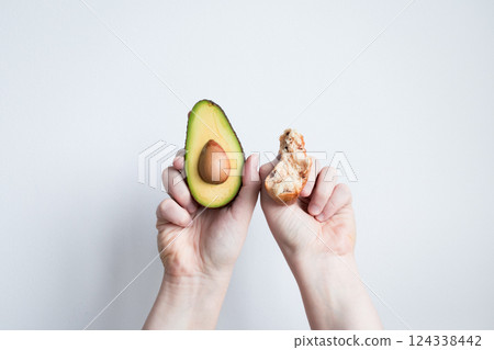 Hands holding fresh avocado and seed against white background Hands holding fresh avocado and seed against white background 124338442