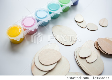 Assorted paints and wooden egg shapes for creative arts and crafts projects Assorted paints and wooden egg shapes for creative arts and crafts projects 124338443
