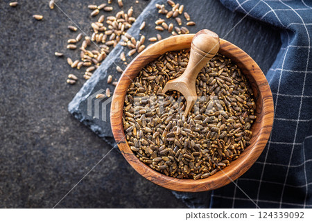 Milk thistle seeds in bowl on black table. Top view. Milk thistle seeds in bowl on black table. Top view. 124339092