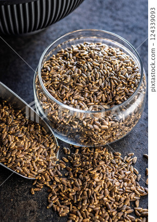 Milk thistle seeds in jar on black table. Milk thistle seeds in jar on black table. 124339093