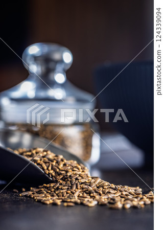 Milk thistle seeds in scoop on black table. Milk thistle seeds in scoop on black table. 124339094