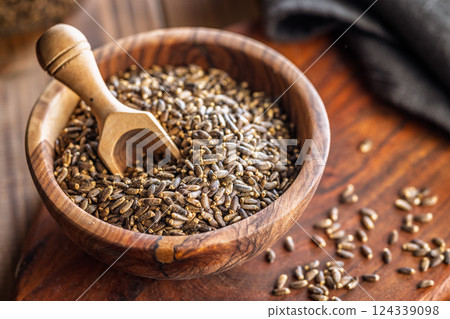 Milk thistle seeds in bowl on wooden table. Milk thistle seeds in bowl on wooden table. 124339098