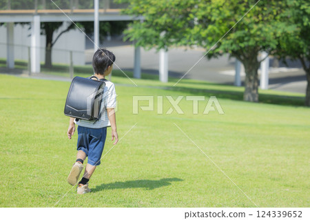 Elementary school student carrying a backpack walking outdoors 124339652