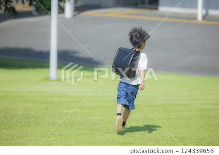 Elementary school student carrying a backpack walking outdoors 124339656