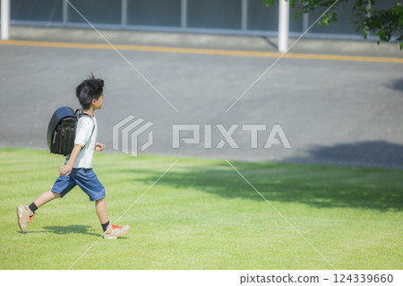 背著書包在戶外散步的小學生 124339660