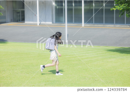 背著書包在戶外散步的小學生 124339784