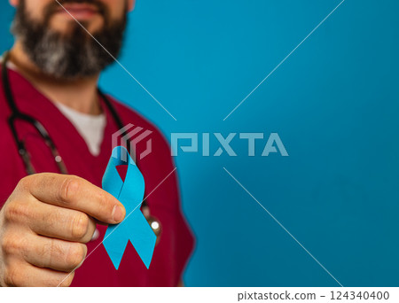Health care professional holding blue awareness ribbon in hospital setting 124340400