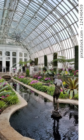 Elegant Glass Conservatory with Lush Gardens, Reflecting Pool, and Statue 124340459