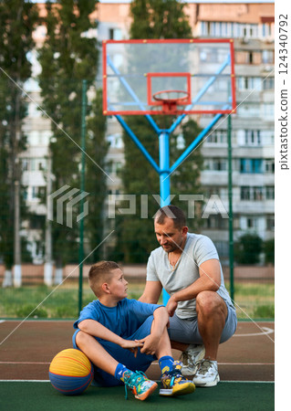 Father and his son enjoying together on basketball court. 124340792