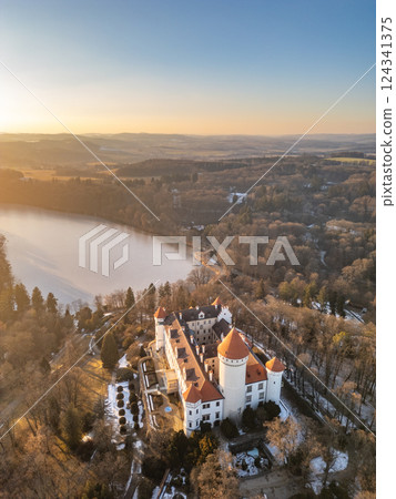 Stunning aerial view of Konopiste Castle in Czechia during sunset, highlighting its majestic towers and surrounding nature. The tranquil lake adds to the enchanting landscape. Stunning aerial view of Konopiste Castle in Czechia during sunset, highlighting its majestic towers and surrounding nature. The tranquil lake adds to the enchanting landscape. 124341375