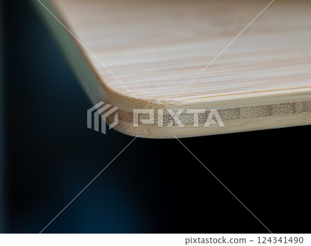 Edge of rounded Plywood as table board, dark background Edge of rounded Plywood as table board, dark background 124341490