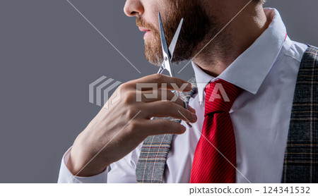 unshaven man hairdressing with scissors isolated on grey background with copy space. 124341532