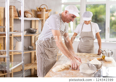 Two bakers work together to prepare dough 124341599