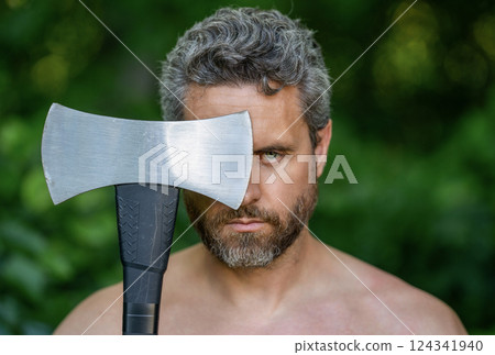 Brutality and masculinity. Hispanic serious man logging with axe. Lumberjack axe. Man with logging axe. Hardworking brutal man. Logging lumberjack man outdoor. Brutal lumberjack 124341940