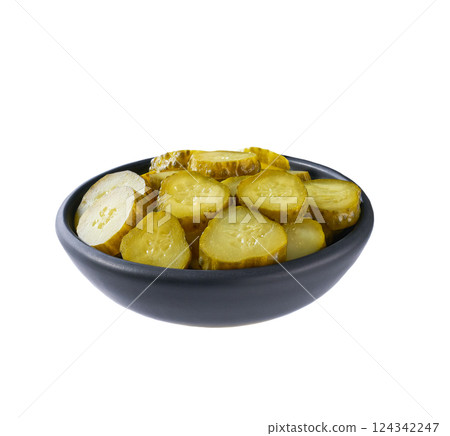 chopped pickled cucumbers in a black bowl isolated on a white background. 124342247