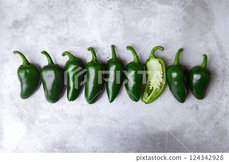 Top view on green mexican jalapeno hot peppers placed in a row 124342928