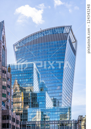 Located in London City, the Fenchurch Building features a unique design with a modern glass facade. Sunlight reflects off its surface, showcasing the changing city skyline around it. 124343248