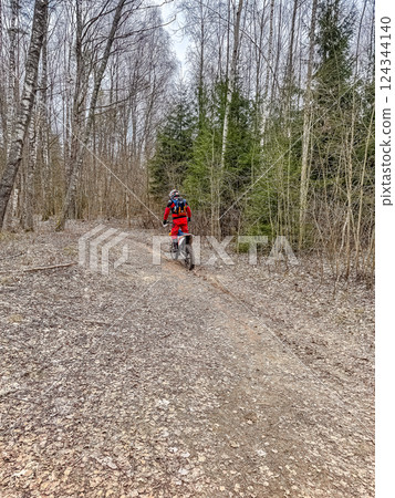 Modern motorcycle on a ride on gravel surface. Motorcycling in nature or offroad, enjoying freedom. Motorbike in the woods. Making a turn. High quality photo 124344140