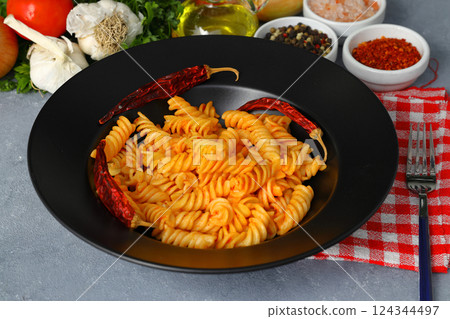 Fusilli pasta in tomato sauce. gray background. Italian food concept Fusilli pasta in tomato sauce. gray background. Italian food concept 124344497